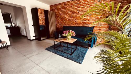 sala de estar con sofá y mesa con flores en Apartamenty Gliwice Staromiejska 65, en Gliwice