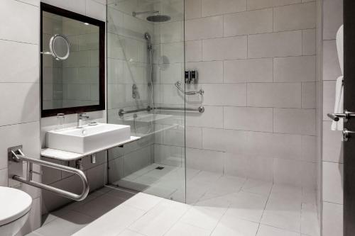 uma casa de banho com uma cabina de duche em vidro e um lavatório. em Four Points by Sheraton Arusha, The Arusha Hotel em Arusha