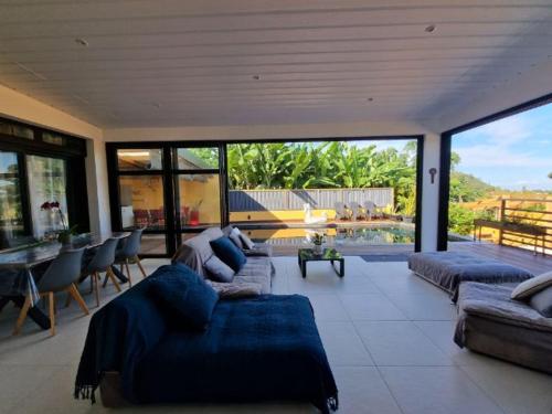 a large living room with couches and a table and chairs at La KAZA-De-LINE in Saint-Joseph