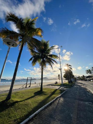 uma rua com palmeiras junto a uma praia em Enseada Beach Hotel no Guarujá