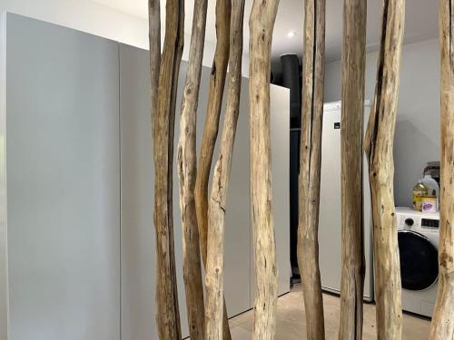 une bande de branches d'arbres dans une pièce avec un réfrigérateur dans l'établissement La villa d'Eva, à Léguillac-de-Lauche