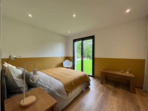 um quarto com uma cama e uma grande janela em La villa d'Eva em Léguillac-de-Lauche