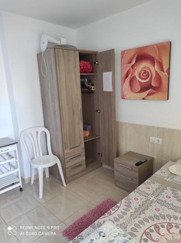 - une chambre avec un lit, une chaise et une armoire dans l'établissement Alojamientos Playa Centro Corralejo 15, à Corralejo