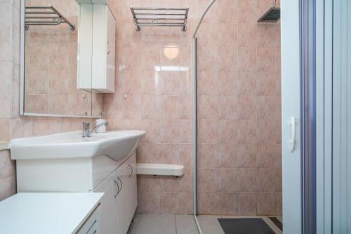uma casa de banho com um lavatório e um chuveiro em Villa Green Panorama em Dubrovnik