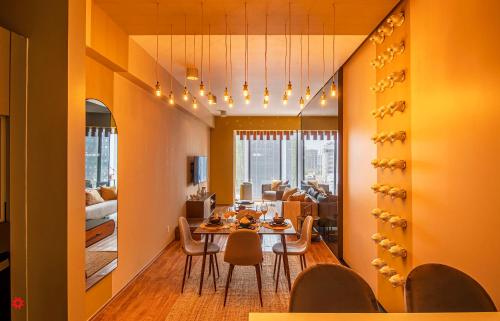 a dining room and living room with a table and chairs at Casa Magenta by Kukun in Mexico City
