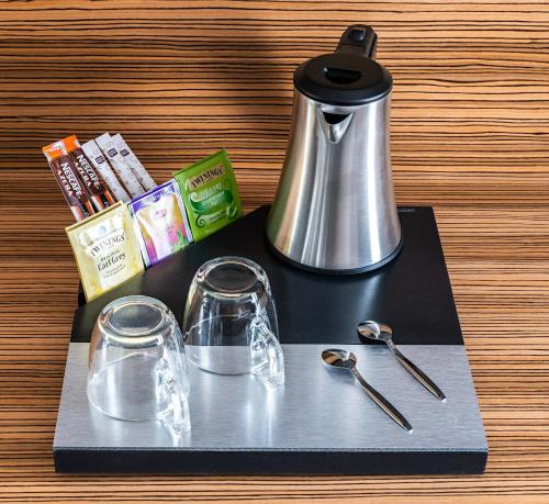 a black tray with a tea kettle and glasses at Hotel Residence Europe & Spa in Clichy