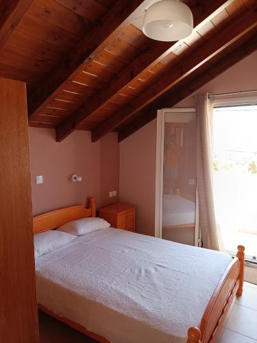a bedroom with a large bed and a window at Apartment Batolios in Agios Georgios