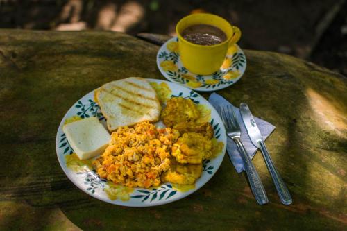 a plate of eggs and bread and a cup of coffee at Cabañas Los Venaos in San Bernardo del Viento