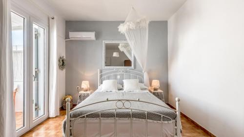a bedroom with a bed and a large window at Litsa Malli Rooms in Pollonia