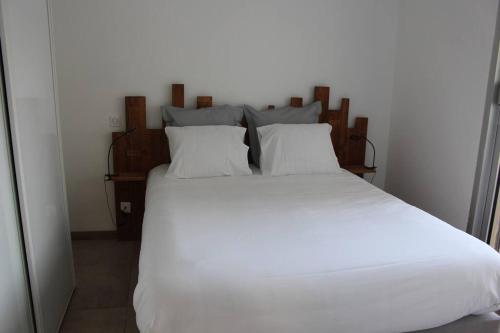 1 cama blanca grande con sábanas y almohadas blancas en Appt 4 pers avec parking privé gratuit Le Touquet, en Le Touquet-Paris-Plage