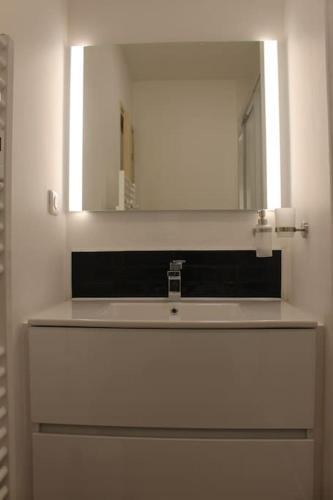 une salle de bain avec un lavabo et un miroir dans l'établissement Appt 4 pers avec parking privé gratuit Le Touquet, à Le Touquet-Paris-Plage