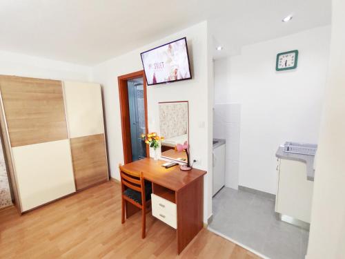 a room with a wooden desk with a vase of flowers on it at Apartmani Buljubašić in Baška Voda