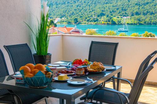 a table with food on it with a view of the water at Sea View Apartments in Grebaštica