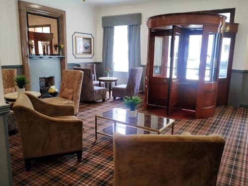 sala de estar con sillas y chimenea en Royal Thurso Hotel, en Thurso