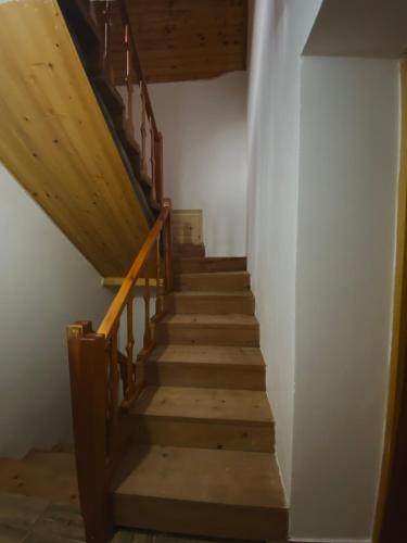a stairway in a house with wooden stairs at Guesthouse Rexhepi in Kolgecaj