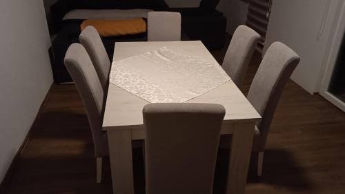 a dining room table with a white table and chairs at MD1 in Trebinje