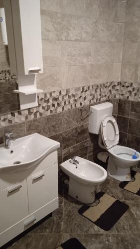 a bathroom with a white toilet and a sink at MD1 in Trebinje