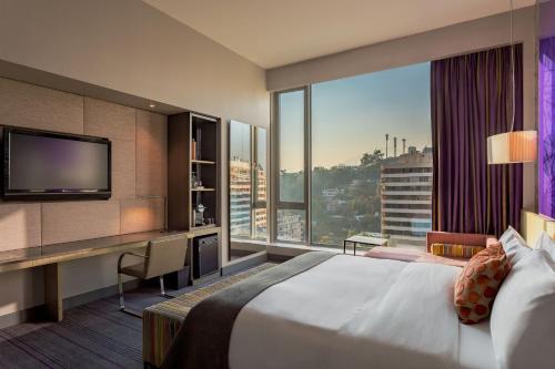 a hotel room with a large bed and a large window at W Santiago in Santiago