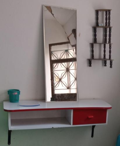 un espejo en un estante con un tocador rojo en Barrio de Santiago Tixtla en Zanjón