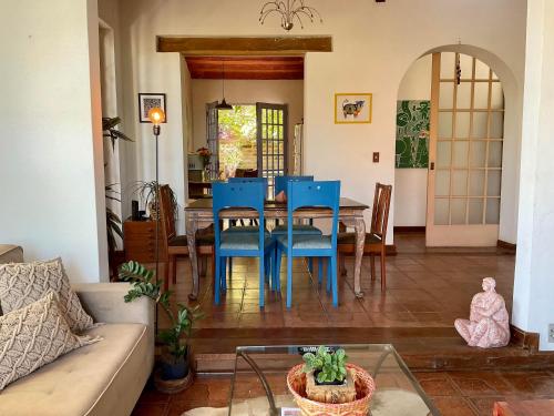 a living room with a table and blue chairs at Residência Acolhedora in Porto Alegre