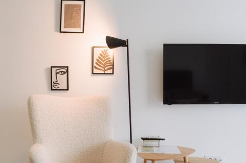 a living room with a chair and a flat screen tv at Boutique Apartment Mostar in Mostar
