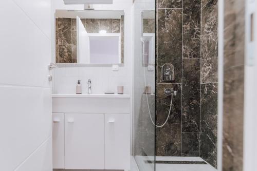 a white bathroom with a shower and a sink at Boutique Apartment Mostar in Mostar