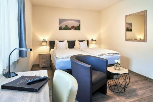 a hotel room with a bed and a chair at Gasthof Gigl in Neustadt an der Donau