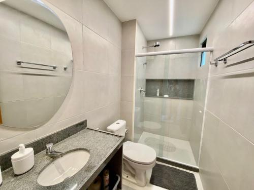 a bathroom with a sink and a toilet and a mirror at Flat luxo 04 torre 06 Eco Resort Carneiros in Tamandaré