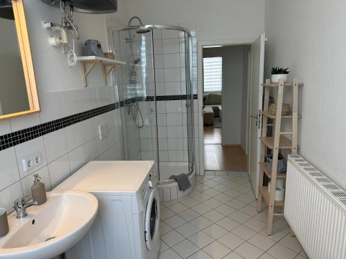 y baño con ducha y lavamanos. en Große Ferienwohnung für Gruppen und Familien bis 8 Personen mit Balkon, en Erfurt