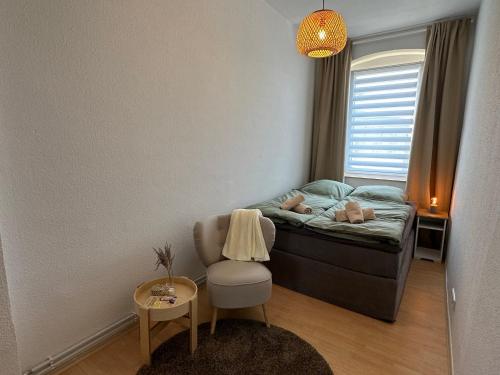 Habitación pequeña con cama y silla en Große Ferienwohnung für Gruppen und Familien bis 8 Personen mit Balkon, en Erfurt