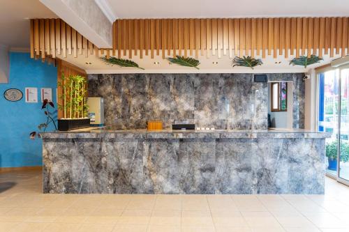 a lobby with a stone wall and a bar at Gumbet Anil Beach in Gümbet