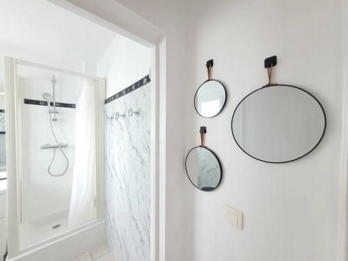 dwa lustra wiszące na ścianie w łazience w obiekcie Studio Lucia - Vue mer w Fréjus