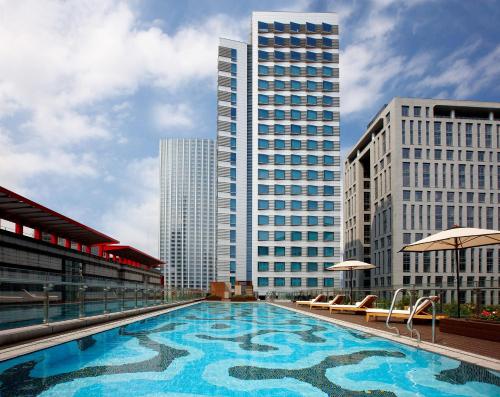 a large swimming pool in a city with tall buildings at Humble House Taipei in Taipei