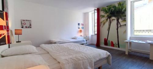 une chambre blanche avec un lit et une fresque de palmier dans l'établissement Villa Barriere - Maison a 25m de la Grande plage, à Les Sables-dʼOlonne