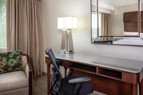 a hotel room with a desk and a mirror at The Westin Waltham Boston in Waltham