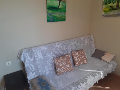 un sofá con 2 almohadas en una habitación en Top floor on villa, 3' from center, by the sea! Host is Efi Kwsta en Preveza