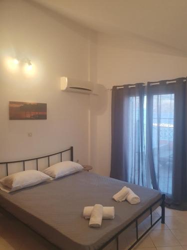 a bedroom with a bed with two towels on it at Johanna Sea View Apartment in Lixouri
