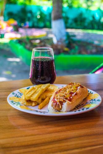 a plate of food with a hot dog and french fries at Cabañas Los Venaos in San Bernardo del Viento