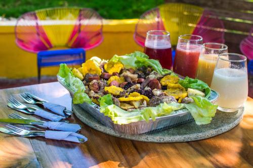 a plate of food on a table with a salad and drinks at Cabañas Los Venaos in San Bernardo del Viento