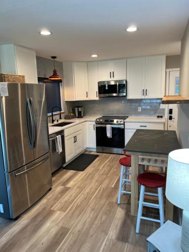 a kitchen with white cabinets and stainless steel appliances at Crescent Bar Waterfront Home- Private Beach, Water Views, Hiking, Golf, Live Concerts in Quincy