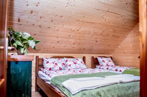 a bed in a room with a wooden wall at Central Chalet in Vărşag