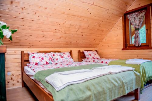 a bedroom with a bed in a log cabin at Central Chalet in Vărşag