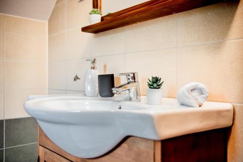 a white bathroom sink with a towel on it at Central Chalet in Vărşag