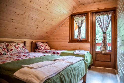 1 dormitorio con 2 camas en una cabaña de madera en Central Chalet en Vărşag