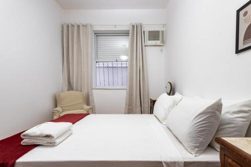 un letto bianco in una stanza con finestra di Gracioso no Leblon - 2 quartos - AP102 a Rio de Janeiro