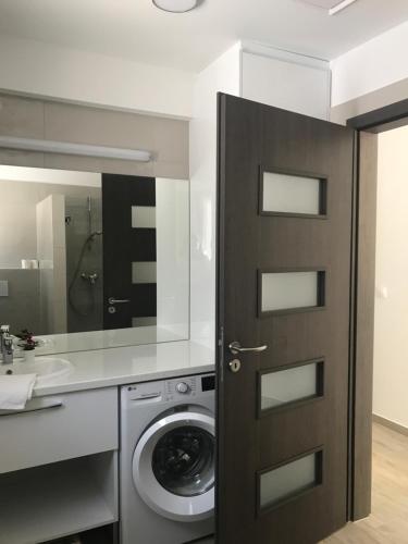 y baño con lavadora y lavamanos. en RoyalHill Apartman en Vonyarcvashegy