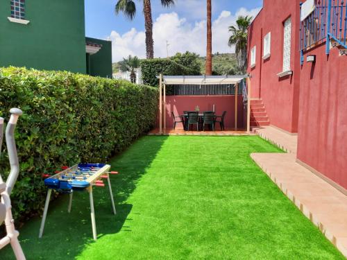 a backyard with green grass and a table and chairs at URBANIZACION MIRAMAR PENISCOLA in Peniscola