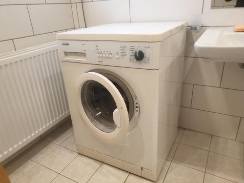 eine Waschmaschine im Bad neben einem Waschbecken in der Unterkunft radlerunterkunft Grabau Nr.1 