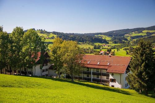 a building with a red roof on a green hill at Appartment 1022, Missen-Wilhams in Missen-Wilhams