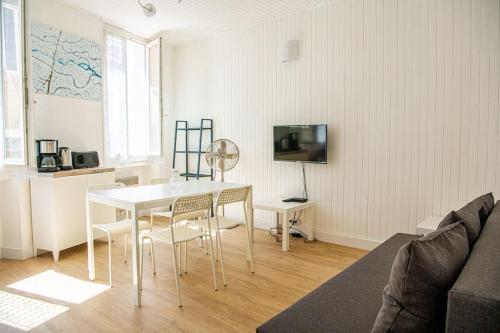 un soggiorno con tavolo e sedie bianchi di Latitude - Appartement proche Notre Dame de la Garde a Marsiglia